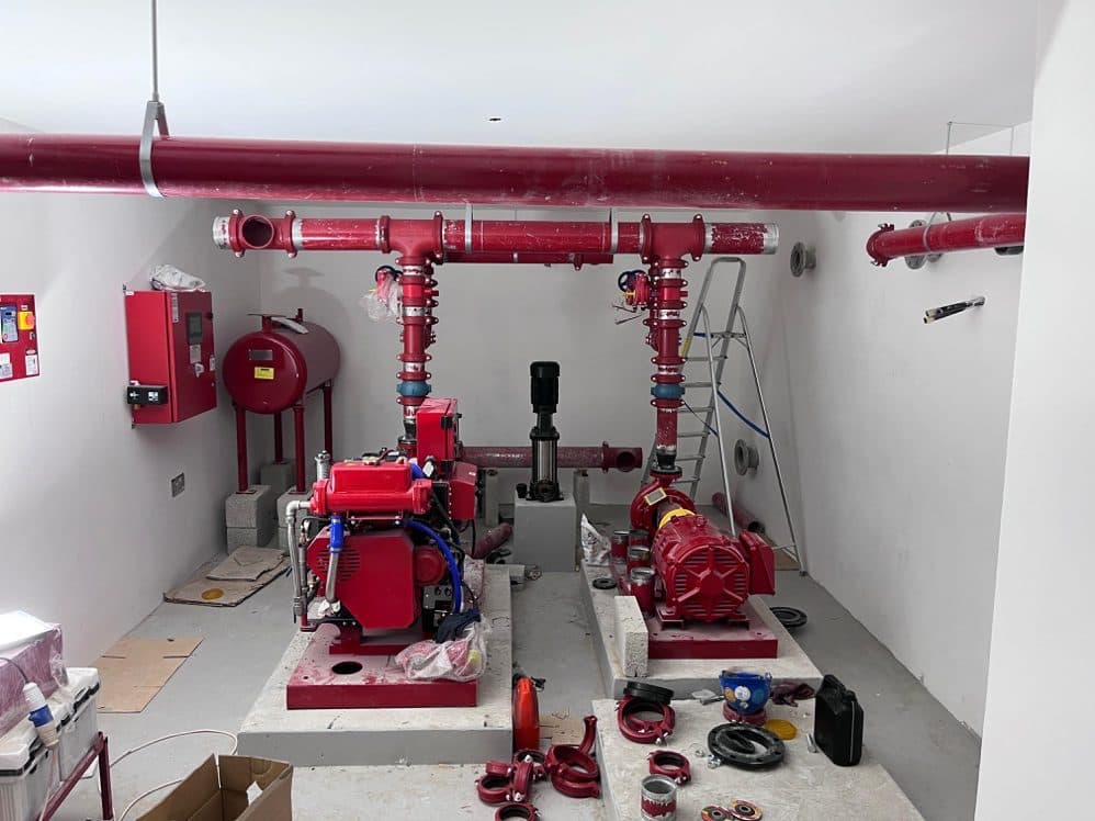 Completed firefighting pump room with red pipework and pumps