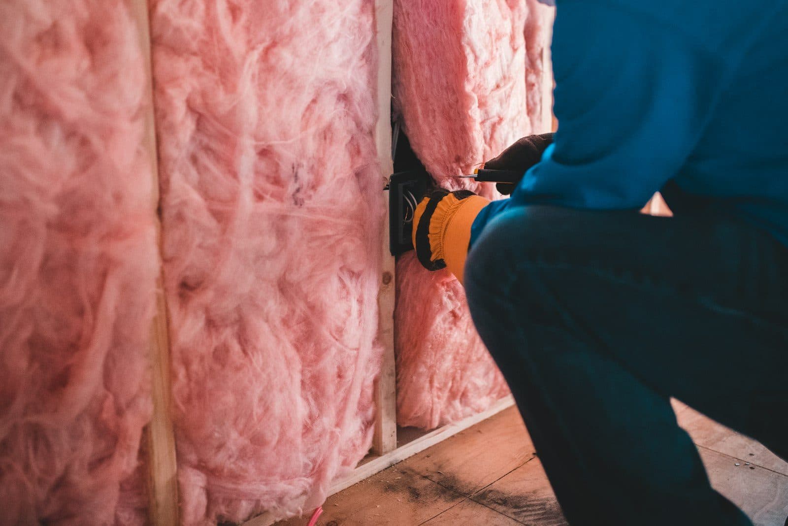 Insulation being installed against a building envelope